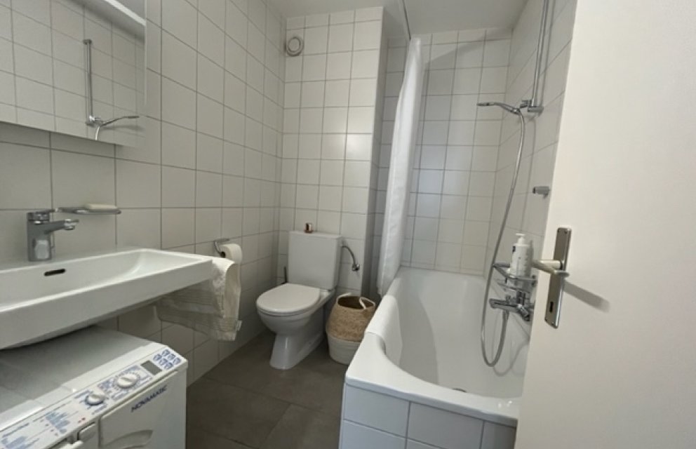 Kleines Badezimmer mit Badewanne und WC